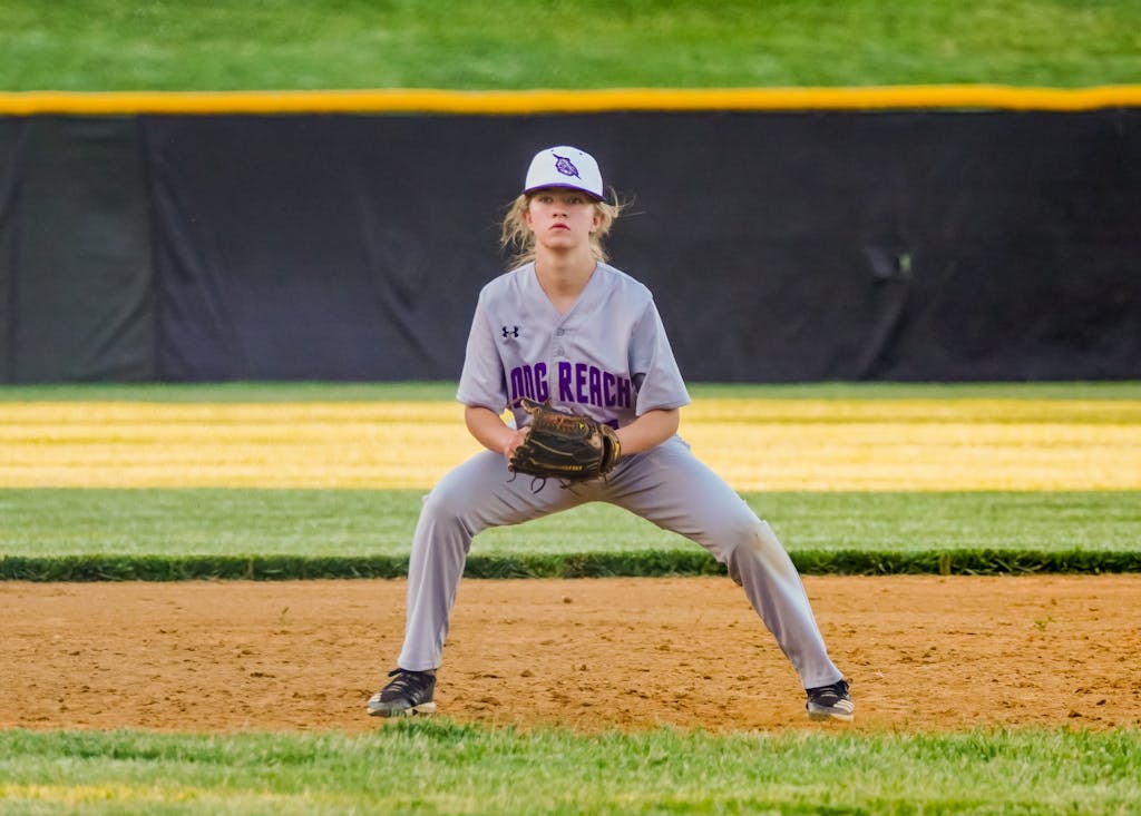 Young softball player focused and ready on the infield during a game.